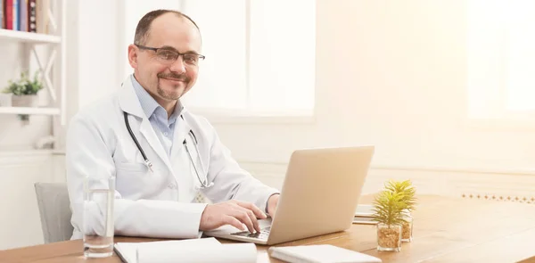 Retrato de médico en gafas sentado en el escritorio — Foto de Stock