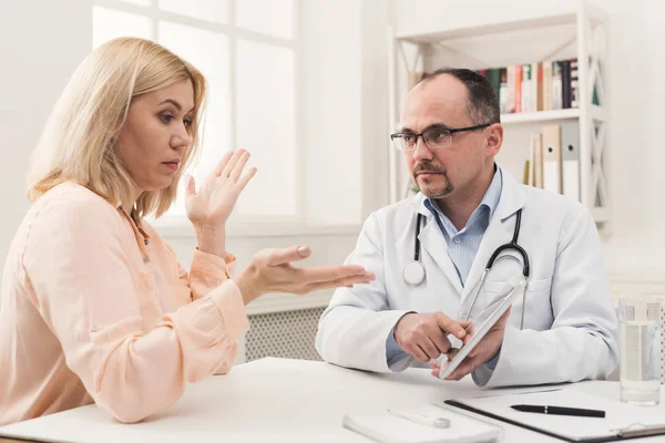 Doctor consulting woman in hospital — Stock Photo, Image