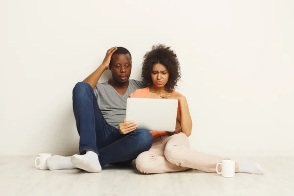 Chockad par använder laptop, sitter på golvet — Stockfoto