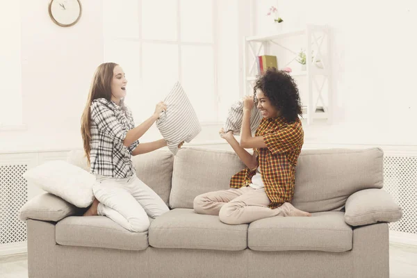 Zwei junge Frauen bei Kissenschlacht auf Sofa — Stockfoto
