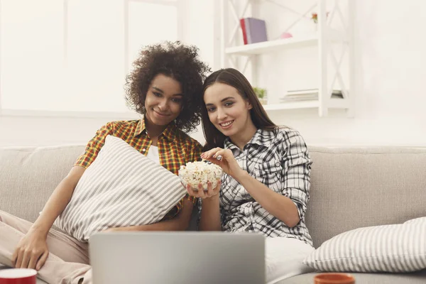 Lächelnde junge Frauen, die sich zu Hause einen Film ansehen — Stockfoto