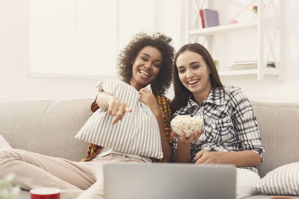 Lächelnde junge Frauen, die sich zu Hause einen Film ansehen — Stockfoto