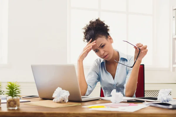 Frustrierte Geschäftsfrau mit Kopfschmerzen im Büro — Stockfoto