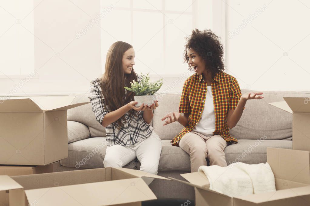Two young women unpacking moving boxes