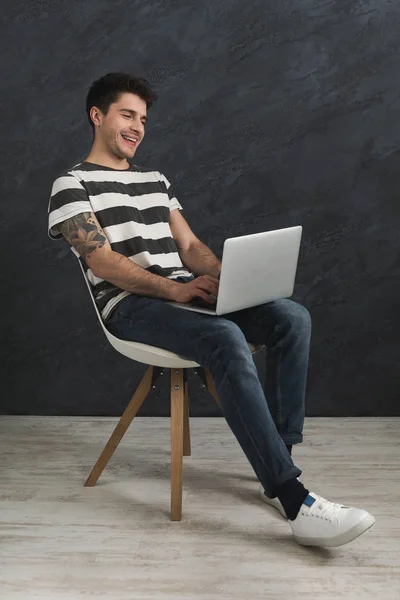 Hombre guapo usando ordenador portátil en el estudio — Foto de Stock