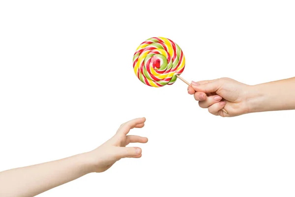 Kid hand reaching for big colorful lollipop — Stock Photo, Image