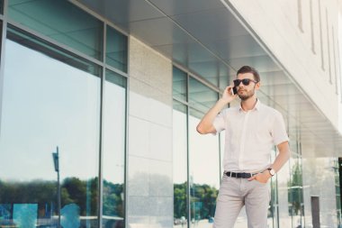 Bir telefon görüşmesi açık havada yapma genç düşünceli işadamı