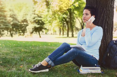 Gülümseyen kadın üzerinde mobil açık havada söz