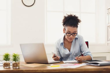 Gülümseyen kadın ofiste not alma