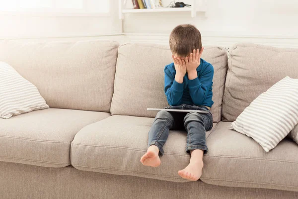 Chico llorón con tableta digital en casa — Foto de Stock