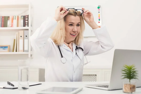 Verbaasd arts met bril zit op bureaublad — Stockfoto