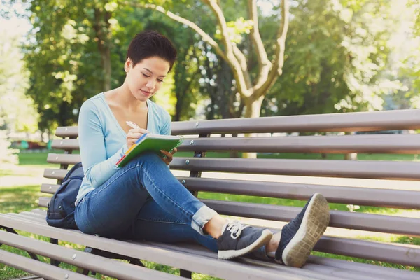 Shorthaired estudiante escribiendo al aire libre — Foto de Stock
