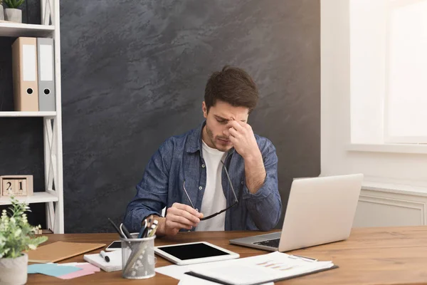Κουρασμένος επιχειρηματίας με το laptop στο μοντέρνο λευκό — Φωτογραφία Αρχείου