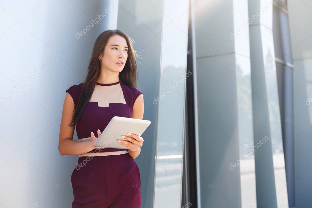 Caucasian businesswoman working with tablet outdoors
