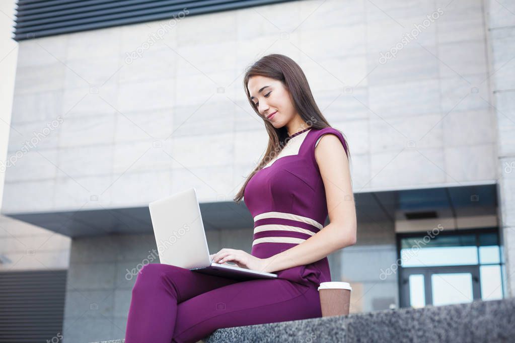 Businesswoman working with laptop outdoors
