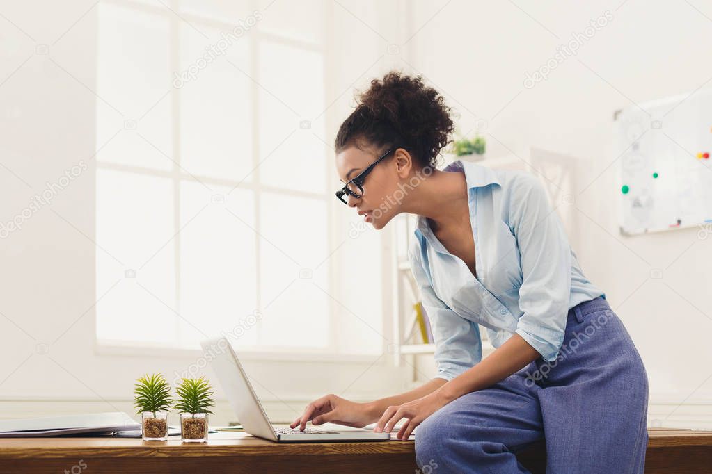 Serious business woman working on laptop at office