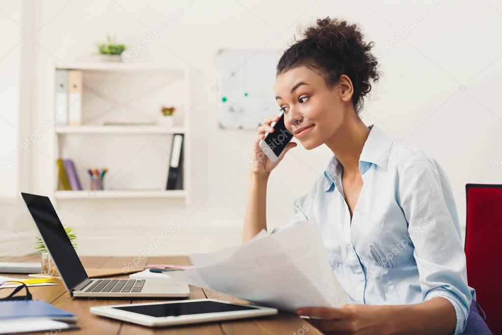 Smiling woman consulting by phone at office