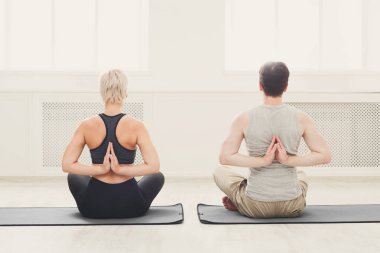 Yoga sınıfındaki genç çift geri germe
