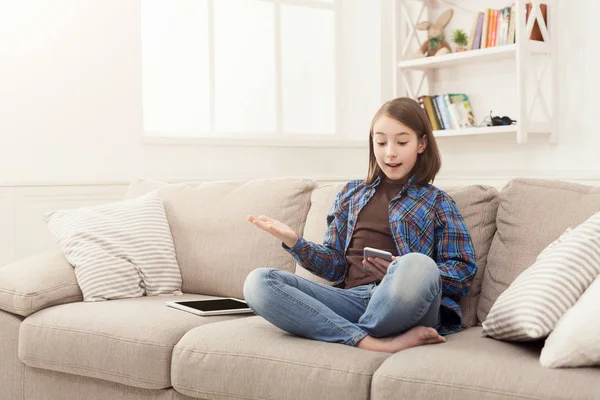 Young shocked girl with tablet at home — Stock Photo, Image