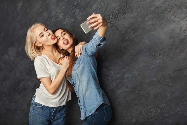 Due donne felici scattare selfie in studio sfondo — Foto Stock