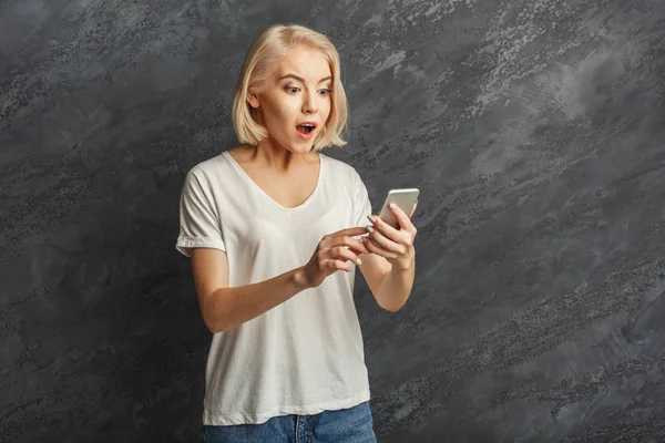 Surprised girl reading good news on mobile — Stock Photo, Image