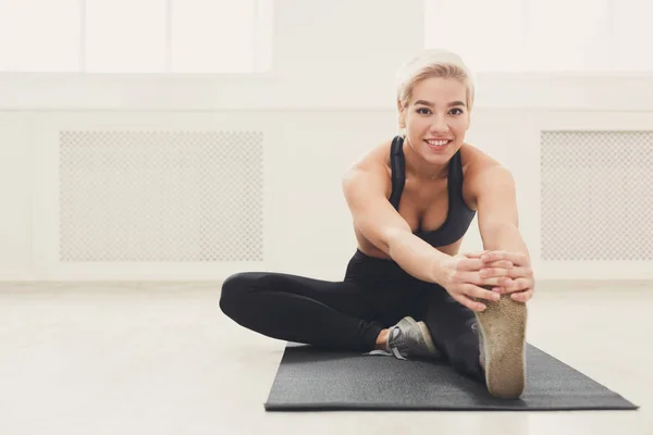 Mujer fitness en el entrenamiento de estiramiento en interiores — Foto de Stock