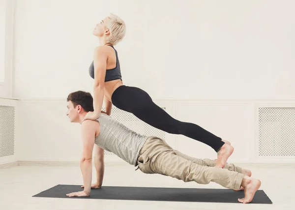 Young couple practicing acroyoga on mat together — Stock Photo, Image