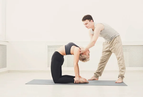 Ung kvinna med yogainstruktör i gymmet — Stockfoto