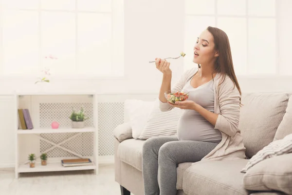 Молода вагітна жінка їсть свіжий зелений салат — стокове фото
