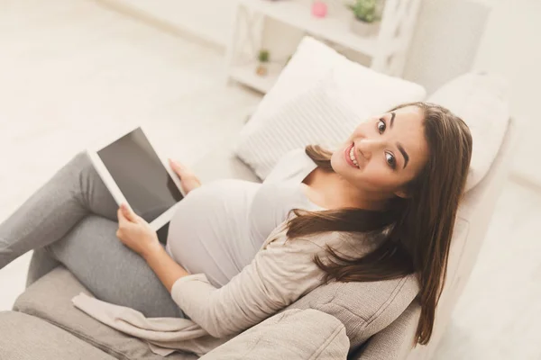 Donna incinta felice utilizzando tablet digitale a casa — Foto Stock