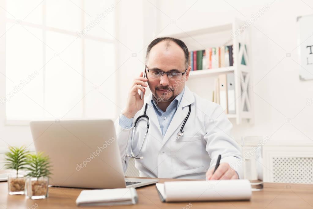 Happy doctor talking on phone with his patient
