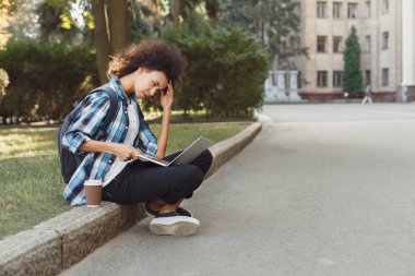 Üniversitede dizüstü bilgisayar kullanan genç kadın