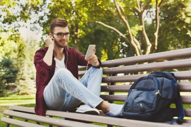 Gülümseyen ve müzik açık havada için dinleme genç adam