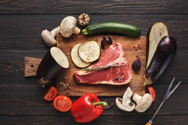 Ahşap tahta üzerinde sebze ile ham t-bone biftek