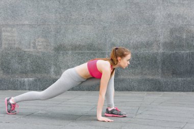 Güzel ve genç birbayan gri duvara germe