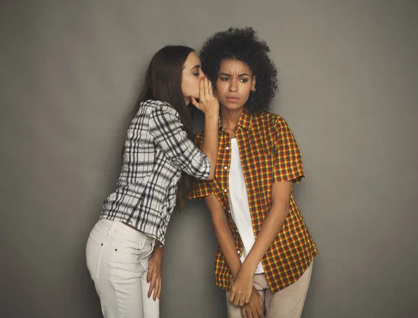 Giovane donna dicendo al suo amico alcuni segreti — Foto Stock
