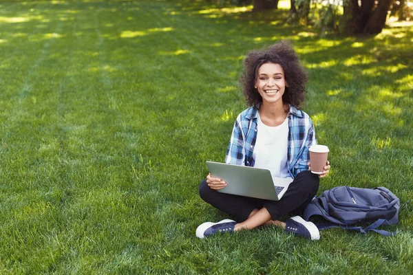 快乐的年轻黑人妇女使用笔记本电脑在公园 — 图库照片