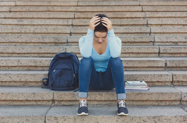 Наголошена студентка сидить на сходах на відкритому повітрі — стокове фото