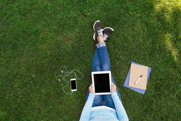 Vista superior de la mujer sentada en la hierba verde con la tableta — Foto de Stock