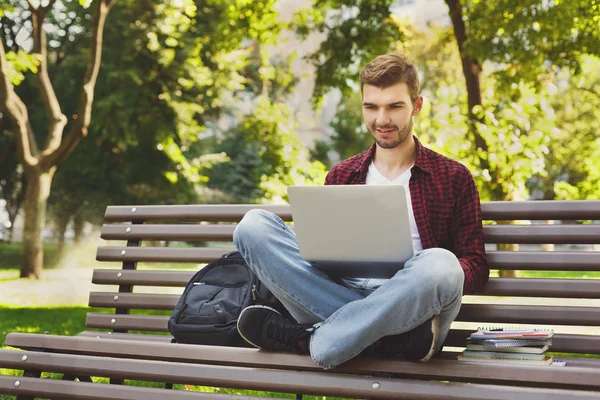 Jonge man met laptop buiten zitten — Stockfoto