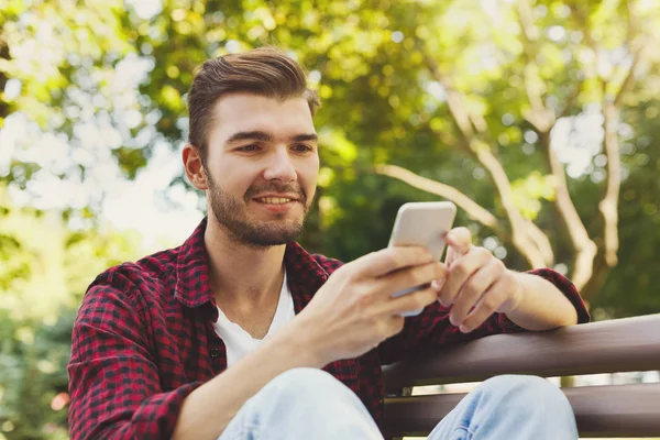 Retrato del hombre sonriente usando el teléfono inteligente al aire libre — Foto de Stock