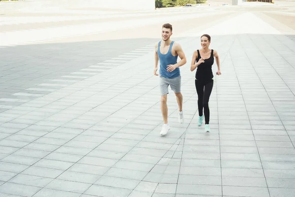 Młoda kobieta i mężczyzna jogging w przestrzeni miasta kopii — Zdjęcie stockowe