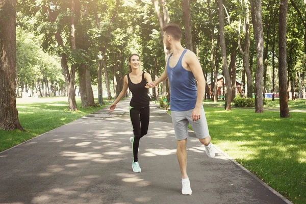 Junges Paar joggt im grünen Park, kopiert Raum — Stockfoto