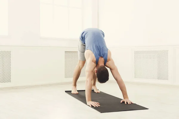 Man utbildning yoga i hund pose, kopia utrymme — Stockfoto