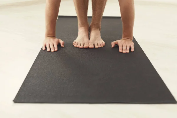Ο άνθρωπος που στέκεται στο yoga mat κατάρτισης του — Φωτογραφία Αρχείου