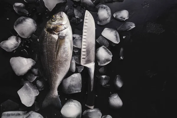 Dorado fresco con hielo sobre fondo negro —  Fotos de Stock