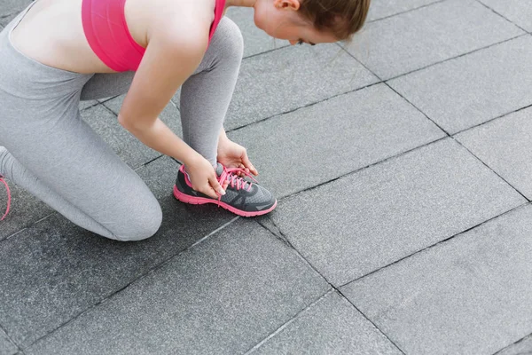 Unrecognizable woman tying shoelaces before running — Stock Photo, Image