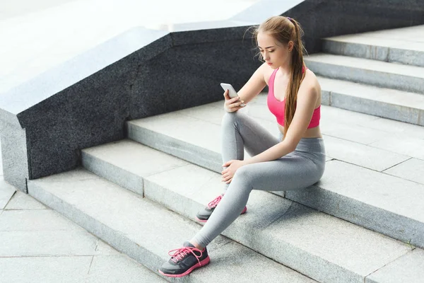 Mulher mensagens de texto no smartphone após o treinamento — Fotografia de Stock