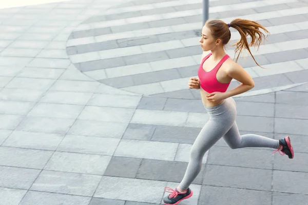 Young woman jogging in city copy space — Stock Photo, Image