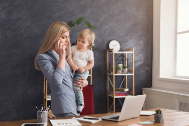 Telefonla konuşurken genç anne holding bebek